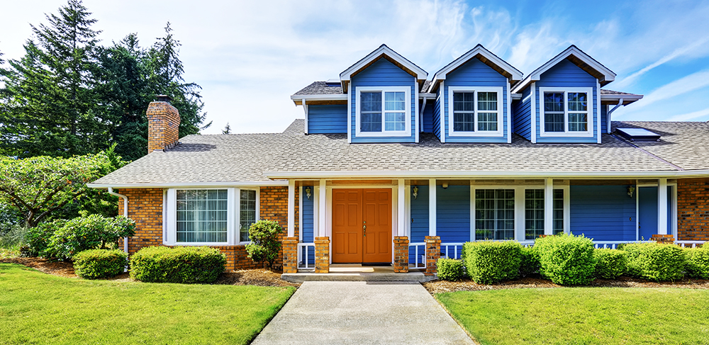 Blue House exterior with an orange door, white trim and a green grass front yard.